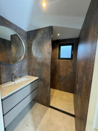 a bathroom with a sink and a mirror at Beach Lodge in Callantsoog