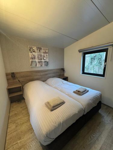 a bedroom with a bed with two towels on it at Beach Lodge in Callantsoog
