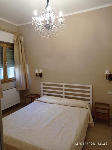 a bedroom with a white bed and a chandelier at Casa Tella in Pula