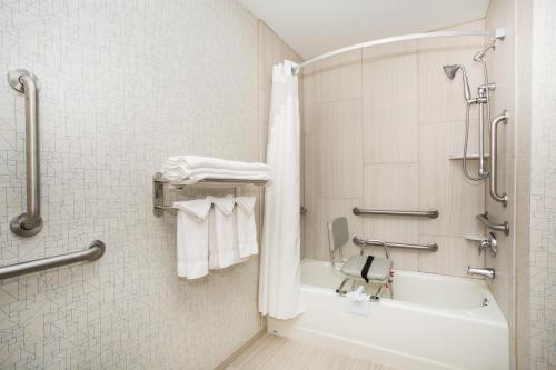 a bathroom with a tub and a shower with towels at Holiday Inn Express & Suites Ft Collins by IHG in Fort Collins