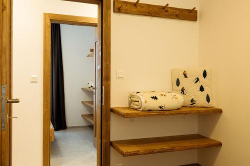a bathroom with a wooden shelf and a mirror at Apartment Horalka - Jasná in Belá