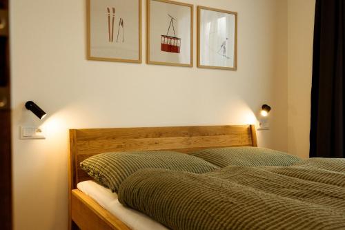a bedroom with a bed and two pictures on the wall at Apartment Horalka - Jasná in Belá