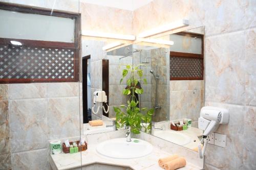 a bathroom with a sink and a mirror at Hotel Lanka Super Corals in Hikkaduwa
