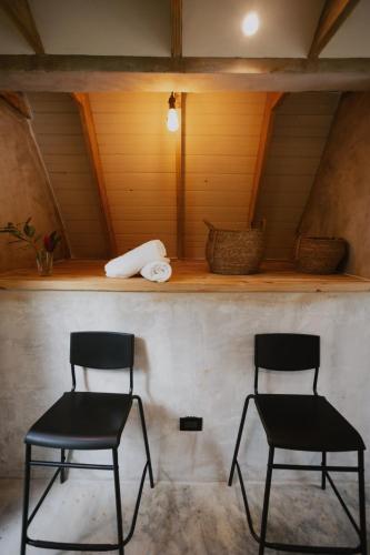 two chairs sitting in a room with a shelf at Casa Cayena - Hibiscus House in El Valle