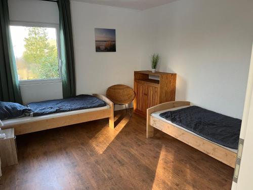 a room with two beds and a window at Gästezimmer Flechtorf in Lehre