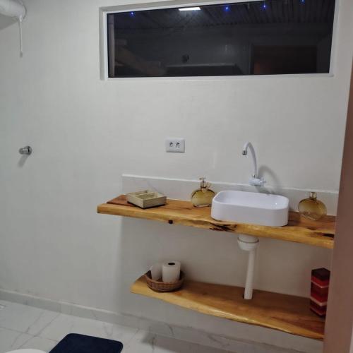 a bathroom with a sink and a mirror at Chácara Sitara - Chalé Safira in Caldas