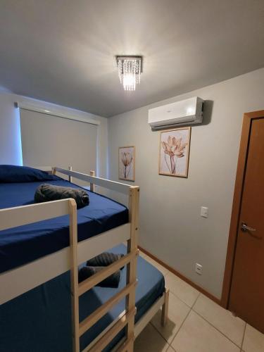a bedroom with two bunk beds and a air conditioner at Ap Clube Piçarras in Piçarras