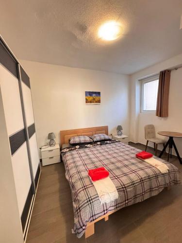 a bedroom with a bed with red pillows on it at Mystras Apartments in Kotor
