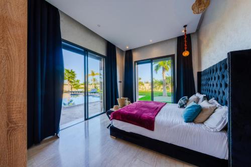a bedroom with a large bed and a large window at Villa Dar E'Zwinna in Marrakesh