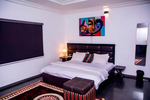 a bedroom with a large bed and a chair at The Close in Asaba