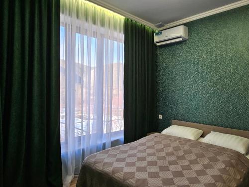 a bedroom with a bed and a large window at Arevot Ojakh in Areni