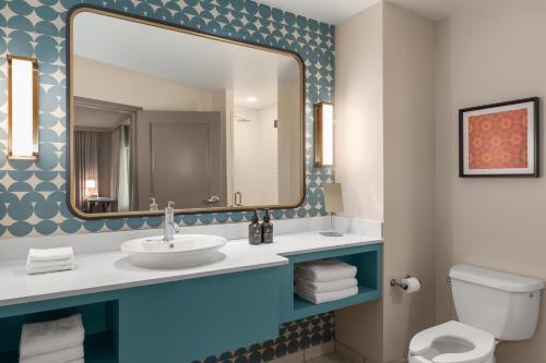 a bathroom with a sink and a mirror at Hotel Indigo Columbus Architectural Center by IHG in Columbus