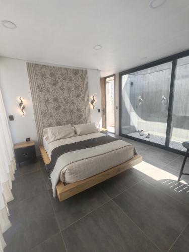 a bedroom with a large bed and a large window at Riviera Mendoza in Las Compuertas