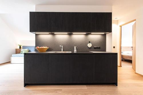 a kitchen with black cabinets and a sink at Senner Nature Stay in Riscone