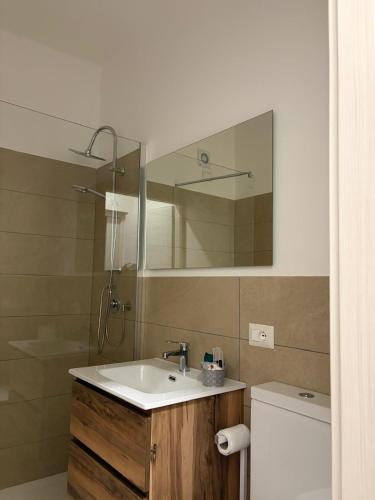 ein Badezimmer mit Waschbecken, Spiegel und Toilette in der Unterkunft Capizzi Rooms in Bronte