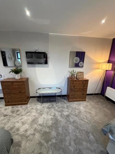 a room with a couch and a tv on a wall at Craven Heifer in Skipton