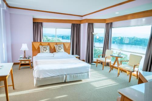 a hotel room with a bed and a large window at Viang Tak Riverside Hotel in Tak