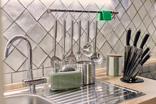 a kitchen counter with a sink and utensils at Vicolo Nobile in Montepulciano