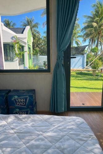 a bedroom with a bed and a large window at An Phú Villa in Cu Lao Thu