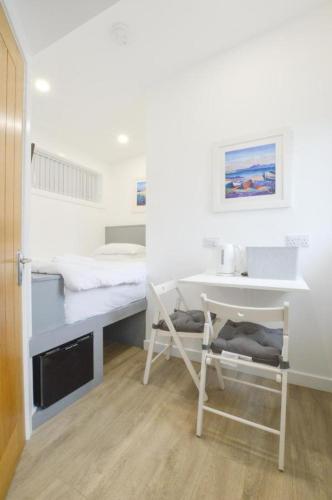 a small room with a desk and a bed at Viewpoint Pods in Dunollie