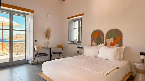 a bedroom with a bed and a table and a balcony at Eleonas Limeni in Limeni