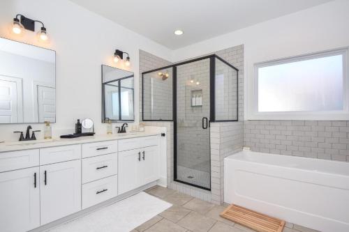 a white bathroom with a tub and a shower at Nova's Nook in Auburn in Auburn