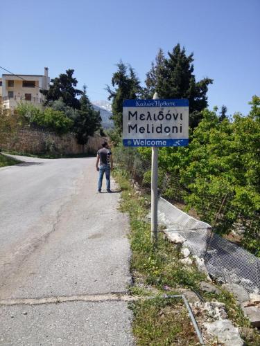 a man standing on the side of a road next to a sign at Stratos Villas in Melidhónion