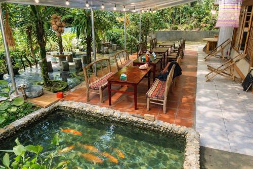 a pool with a table and chairs and a fish in the water at Tả Mẩy Homestay in Lao Cai
