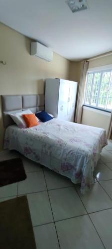 a bedroom with a bed in a room with a window at Casa inigualavel in Caucaia