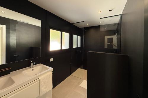 a black bathroom with a sink and a mirror at Casablanca-Private Family Mountain Home in El Amunt