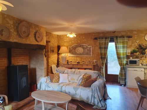 a living room with a couch and a table at Les Girouteaux La bergerie in Les Eyzies-de-Tayac