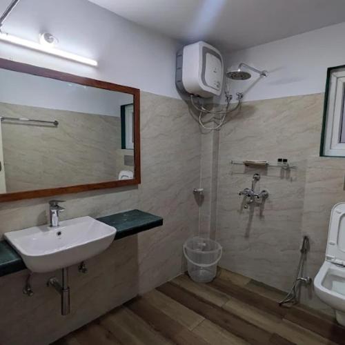 a bathroom with a shower and a sink and a mirror at Stay At Cottages in Pynursla