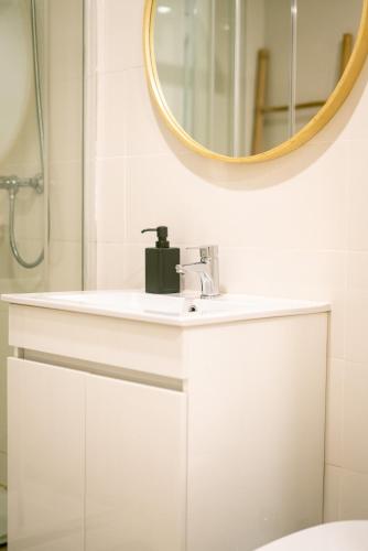 a bathroom with a white sink and a mirror at Magnificent Cais de Gaia Duplex in Vila Nova de Gaia