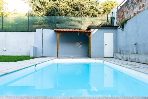 a swimming pool with blue water in a backyard at Magnificent Cais de Gaia Duplex in Vila Nova de Gaia