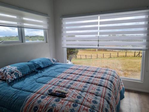 a bedroom with a bed and a large window at Cabañas alto Volcanes, Puerto Montt in Puerto Montt