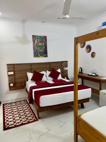 a bedroom with a bed with red and white sheets at Kendwa Crystal Coast Hotel in Kendwa