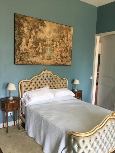a bedroom with a bed with a painting on the wall at Château des Fouilloux in Agris