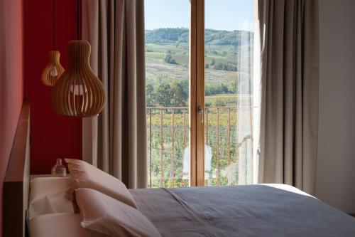 a bedroom with a bed and a large window at Agriturismo Cà Vida in Ziano Piacentino