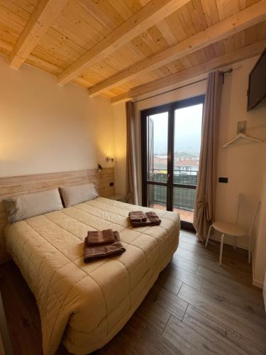 a bedroom with a large bed with a large window at Homely - Malpensa & Fiere Milano in Cardano al Campo