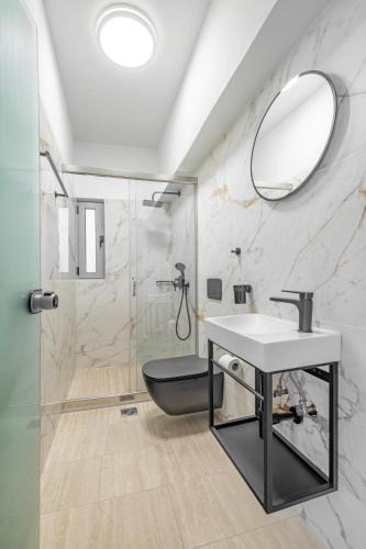 a bathroom with a sink and a toilet and a mirror at Rhodes center Santa Marina in Rhodes Town