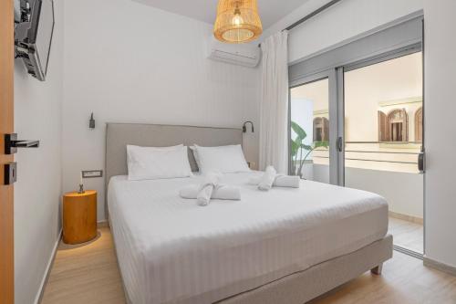 a bedroom with a large white bed with a window at Rhodes center Santa Marina in Rhodes Town