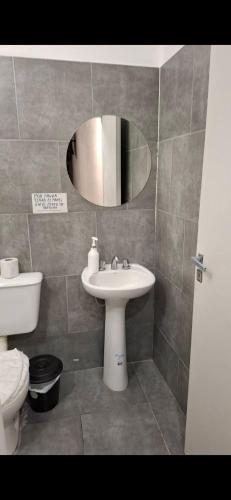a bathroom with a sink and a toilet and a mirror at Umbrella4 in La Rioja