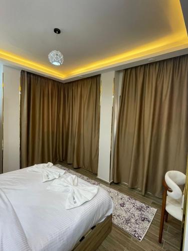 a bedroom with a white bed and a chair at VERO Residence in Hurghada