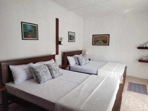 two beds in a room with white walls at Hatton Easy Stay in Hatton
