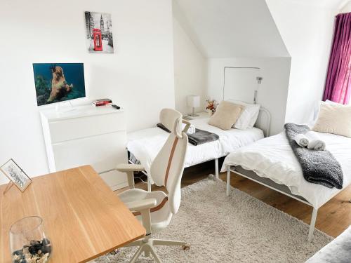 a living room with two beds and a table at 11 Guests - 6min Drive to the Wembley Stadium in London