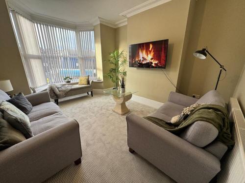 a living room with two couches and a fireplace at Stylish home from home in Nether Edge