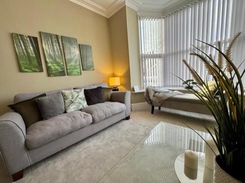 a living room with a couch and a table at Stylish home from home in Nether Edge
