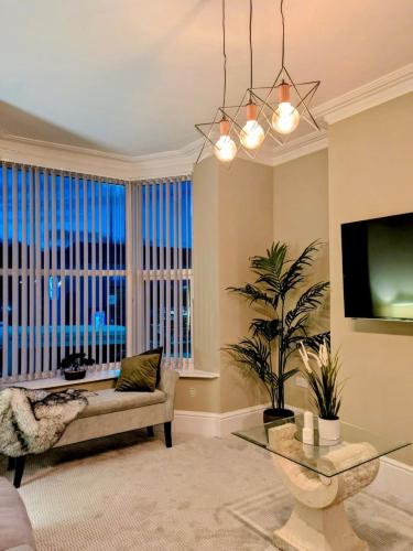 a living room with a couch and a tv at Stylish home from home in Nether Edge