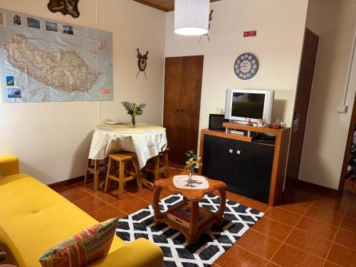 a living room with a yellow couch and a table at House in Camara de Lobos in Estreito de Câmara de Lobos