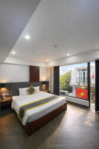 a bedroom with a large bed and a large window at Moonlight Boutique Hotel in Hue